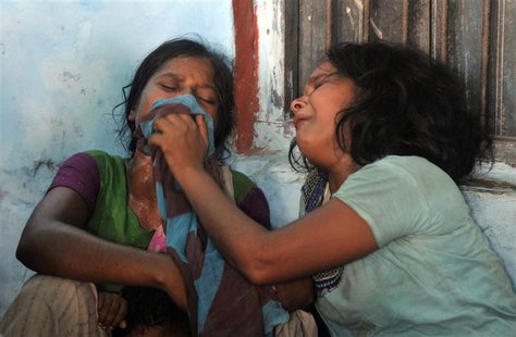 Women mourn the death of their children who died after consuming contaminated meals given to children at a school on Tuesday at Chapra in th Women mourn the death of their children who died after consuming contaminated meals given to children at a school on Tuesday at Chapra in th