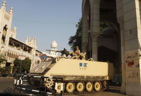 An Egyptian soldier keeps guard from atop a military vehicle in front of the presidential palace in Cairo July 14, 2013. REUTERS/Asmaa Wagui An Egyptian soldier keeps guard from atop a military vehicle in front of the presidential palace in Cairo July 14, 2013. REUTERS/Asmaa Wagui