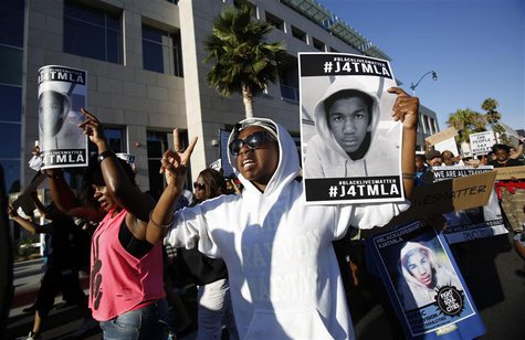 Camille Quinones Miller holds a placard as she chants slogans during a march to protest the acquittal of George Zimmerman in the killing of Camille Quinones Miller holds a placard as she chants slogans during a march to protest the acquittal of George Zimmerman in the killing of