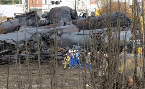 A firefighter and an emergency crew work on the site of the train wreck in Lac Megantic, July 16, 2013. REUTERS/Ryan Remiorz/Pool A firefighter and an emergency crew work on the site of the train wreck in Lac Megantic, July 16, 2013. REUTERS/Ryan Remiorz/Pool