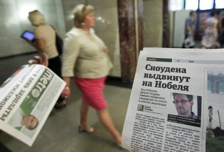 An employee distributes newspapers, with a photograph (R) of former U.S. spy agency contractor Edward Snowden seen on a page, at an undergro An employee distributes newspapers, with a photograph (R) of former U.S. spy agency contractor Edward Snowden seen on a page, at an undergro