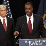Detroit Emergency Manager Kevyn Orr (R) addresses the media as Michigan Governor Rick Snyder listens during a news conference about filing b Detroit Emergency Manager Kevyn Orr (R) addresses the media as Michigan Governor Rick Snyder listens during a news conference about filing b