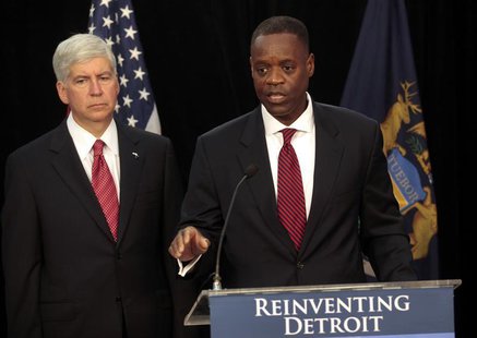 Detroit Emergency Manager Kevyn Orr (R) addresses the media as Michigan Governor Rick Snyder listens during a news conference about filing b Detroit Emergency Manager Kevyn Orr (R) addresses the media as Michigan Governor Rick Snyder listens during a news conference about filing b