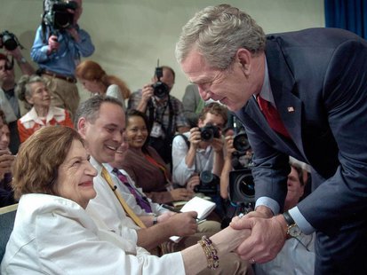 U.S. President George W. Bush greets veteran reporter Helen Thomas (L) during a surprise visit to a briefing in the press briefing room of t U.S. President George W. Bush greets veteran reporter Helen Thomas (L) during a surprise visit to a briefing in the press briefing room of t