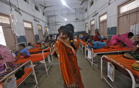 A woman carries her niece who got sick after consuming contaminated meals given to children at a school on Tuesday, in the eastern Indian ci A woman carries her niece who got sick after consuming contaminated meals given to children at a school on Tuesday, in the eastern Indian ci