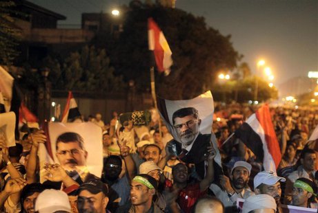 Supporters of deposed Egyptian president Mohamed Mursi hold up Egyptian national flags and posters of Mursi, as they chant slogans during a Supporters of deposed Egyptian president Mohamed Mursi hold up Egyptian national flags and posters of Mursi, as they chant slogans during a