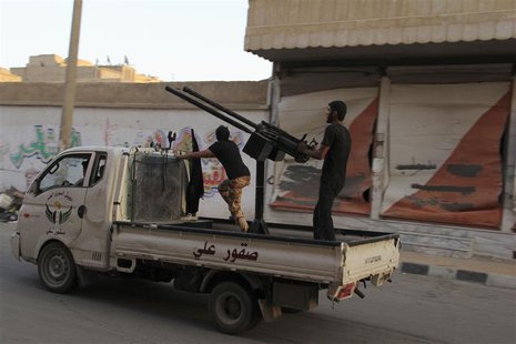 A Free Syrian Army fighter aims an anti-aircraft gun as he stands on the back of a truck in Deir al-Zor July 19, 2013. Picture taken July 19 A Free Syrian Army fighter aims an anti-aircraft gun as he stands on the back of a truck in Deir al-Zor July 19, 2013. Picture taken July 19