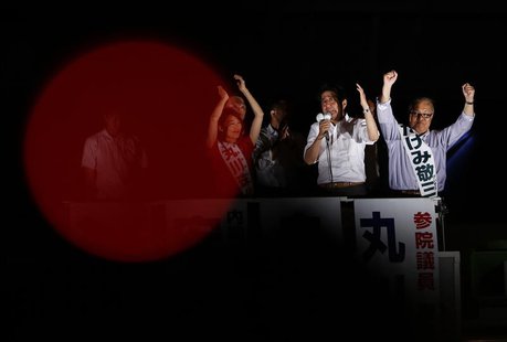 Japan's Prime Minister Shinzo Abe (2nd R), and the leader of the ruling Liberal Democratic Party, speaks to voters atop a van during a campa Japan's Prime Minister Shinzo Abe (2nd R), and the leader of the ruling Liberal Democratic Party, speaks to voters atop a van during a campa