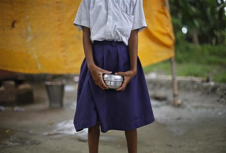 A school girl holds a container to receive her free mid-day meal, distributed by a government-run primary school, at Brahimpur village in Ch A school girl holds a container to receive her free mid-day meal, distributed by a government-run primary school, at Brahimpur village in Ch