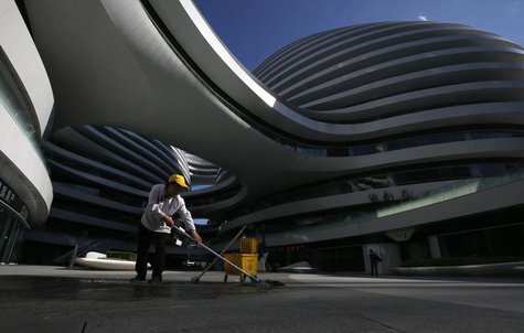 A cleaner works at a newly built business building in Beijing July 16, 2013. REUTERS/Kim Kyung-Hoon A cleaner works at a newly built business building in Beijing July 16, 2013. REUTERS/Kim Kyung-Hoon