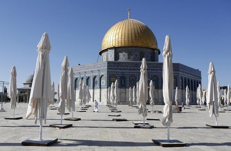 Palestinians walk amongst parasols placed outside the Dome of the Rock on the compound know to Muslims as "al-Haram al-Sharif" and to Jews a Palestinians walk amongst parasols placed outside the Dome of the Rock on the compound know to Muslims as "al-Haram al-Sharif" and to Jews a