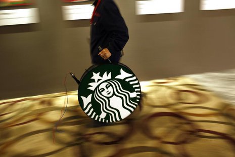 A man carries a Starbucks logo sign after a corporate event at a hotel in Shanghai April 19, 2012. REUTERS/Carlos Barria A man carries a Starbucks logo sign after a corporate event at a hotel in Shanghai April 19, 2012. REUTERS/Carlos Barria