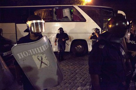 Police guard a bus trying to get deputies out of the parliament where they had been discussing budget measures, from protesters opposing the Police guard a bus trying to get deputies out of the parliament where they had been discussing budget measures, from protesters opposing the