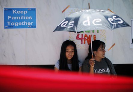 Diana Mendez (R), 39 and Ana Hernandez, 11, shelter from the sun at a 24-hour vigil calling on Congress to pass immigration reform in Los An Diana Mendez (R), 39 and Ana Hernandez, 11, shelter from the sun at a 24-hour vigil calling on Congress to pass immigration reform in Los An