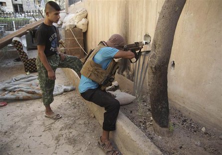 A Free Syrian Army fighter aims his weapon as he takes a defensive position in Deir al-Zor July 23, 2013. REUTERS/Khalil Ashawi A Free Syrian Army fighter aims his weapon as he takes a defensive position in Deir al-Zor July 23, 2013. REUTERS/Khalil Ashawi