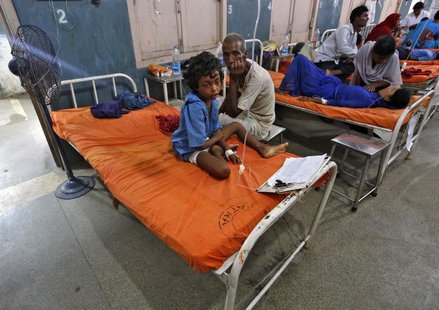 A sick girl Khushi Kumari (C) sits next to her grandfather inside a hospital, after she consumed contaminated meals given to children at a s A sick girl Khushi Kumari (C) sits next to her grandfather inside a hospital, after she consumed contaminated meals given to children at a s