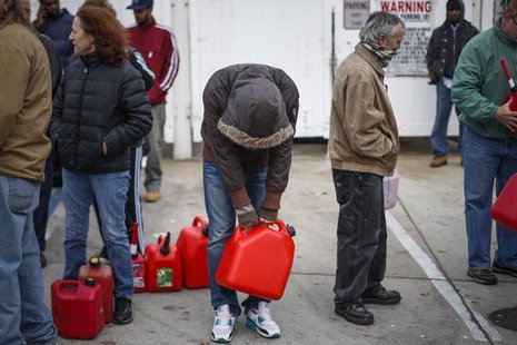 A man stands exhausted while waiting for over five hours to receive fuel from a gas station in Queens, a borough in New York which was left A man stands exhausted while waiting for over five hours to receive fuel from a gas station in Queens, a borough in New York which was left