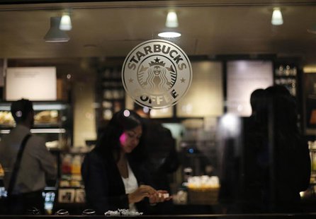 A woman prepares her drink in a Starbucks store in New York in this file photo from June 25, 2013. REUTERS/Brendan McDermid /Files A woman prepares her drink in a Starbucks store in New York in this file photo from June 25, 2013. REUTERS/Brendan McDermid /Files