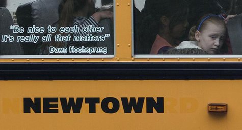 Students sit behind a quote by slain Sandy Hook Elementary School principal Dawn Hochsprung, displayed on the window of a school bus, as it Students sit behind a quote by slain Sandy Hook Elementary School principal Dawn Hochsprung, displayed on the window of a school bus, as it