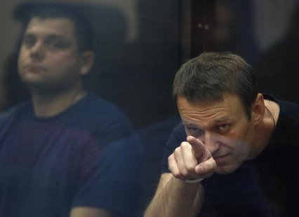 Russian protest leader Alexei Navalny (R) and his co-defendant Pyotr Ofitserov sit in a glass-walled cage during a court session in Kirov, J Russian protest leader Alexei Navalny (R) and his co-defendant Pyotr Ofitserov sit in a glass-walled cage during a court session in Kirov, J