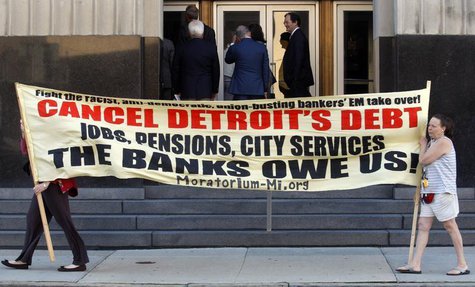 Protesters carry a banner calling for Detroit's debt to be cancelled as people enter the federal courthouse for day one of Detroit's municip Protesters carry a banner calling for Detroit's debt to be cancelled as people enter the federal courthouse for day one of Detroit's municip