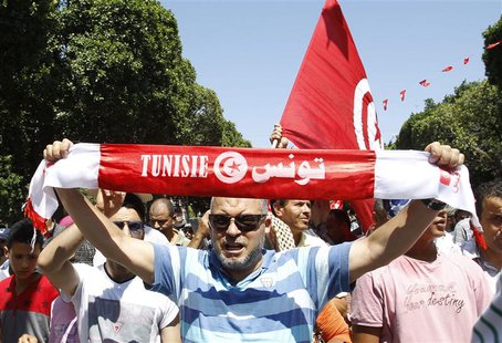 A supporter of the Islamist Ennahda movement holds up a scarf as he chants slogans during a demonstration in Tunis July 26, 2013. REUTERS/Zo A supporter of the Islamist Ennahda movement holds up a scarf as he chants slogans during a demonstration in Tunis July 26, 2013. REUTERS/Zo