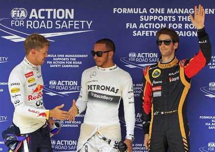 Mercedes Formula One driver Lewis Hamilton (C) of Britain shakes hands with Red Bull Formula One driver Sebastian Vettel (L) of Germany as L Mercedes Formula One driver Lewis Hamilton (C) of Britain shakes hands with Red Bull Formula One driver Sebastian Vettel (L) of Germany as L