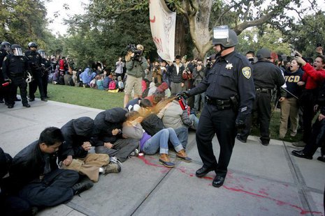 A University of California Davis police officer pepper-sprays students during their sit-in at an "Occupy UCD" demonstration in Davis, Califo A University of California Davis police officer pepper-sprays students during their sit-in at an "Occupy UCD" demonstration in Davis, Califo