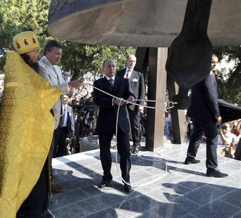 Russian President Vladimir Putin (C) and Ukrainian President Viktor Yanukovich (2nd L) ring a newly installed bell during a service at the S Russian President Vladimir Putin (C) and Ukrainian President Viktor Yanukovich (2nd L) ring a newly installed bell during a service at the S