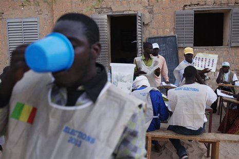A poll worker breaks his Ramadan fast with water as other workers count ballots after the end of voting in Mali's presidential elections in A poll worker breaks his Ramadan fast with water as other workers count ballots after the end of voting in Mali's presidential elections in