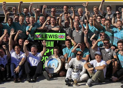 Mercedes Formula One driver Lewis Hamilton of Britain poses with his trophy and members of the Mercedes team, including team principal Ross Mercedes Formula One driver Lewis Hamilton of Britain poses with his trophy and members of the Mercedes team, including team principal Ross
