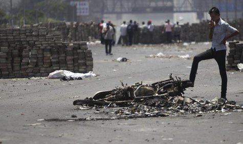 A member of the Muslim Brotherhood and supporter of deposed Egyptian President Mohamed Mursi stands near a burnt motorcycle after late night A member of the Muslim Brotherhood and supporter of deposed Egyptian President Mohamed Mursi stands near a burnt motorcycle after late night