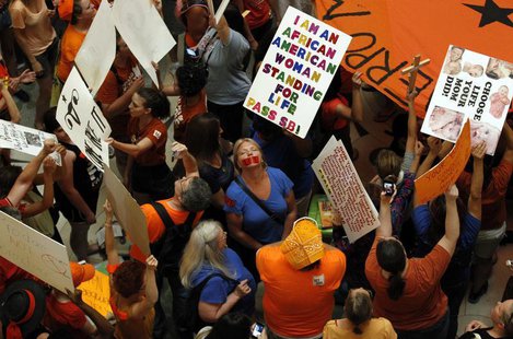 Abortion rights (in orange) and anti-abortion advocates (in blue) rally in the rotunda of the State Capitol, as the state Senate meets to co Abortion rights (in orange) and anti-abortion advocates (in blue) rally in the rotunda of the State Capitol, as the state Senate meets to co