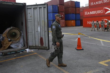 A police officer walks next to a container holding a MiG-21 fighter jet engine from the seized North Korean-flagged ship Chong Chon Gang, at A police officer walks next to a container holding a MiG-21 fighter jet engine from the seized North Korean-flagged ship Chong Chon Gang, at