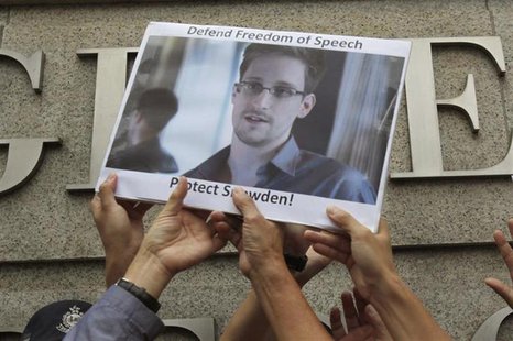 Protesters supporting Edward Snowden, a contractor at the National Security Agency (NSA), hold a photo of Snowden during a demonstration out Protesters supporting Edward Snowden, a contractor at the National Security Agency (NSA), hold a photo of Snowden during a demonstration out
