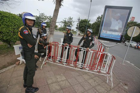 Military policemen stand in front of a poster of Cambodia's long-ruling Prime Minister Hun Sen in central Phnom Penh July 30, 2013. REUTERS/ Military policemen stand in front of a poster of Cambodia's long-ruling Prime Minister Hun Sen in central Phnom Penh July 30, 2013. REUTERS/
