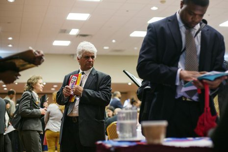 A man walks past job seekers as they fill out job applications for recruiters during a job fair in New York, June 11, 2013. REUTERS/Lucas Ja A man walks past job seekers as they fill out job applications for recruiters during a job fair in New York, June 11, 2013. REUTERS/Lucas Ja