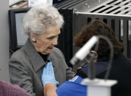 A Transportation Security Administration (TSA) worker (R) rubs her hands across a elderly female traveler's chest during a patdown search at A Transportation Security Administration (TSA) worker (R) rubs her hands across a elderly female traveler's chest during a patdown search at