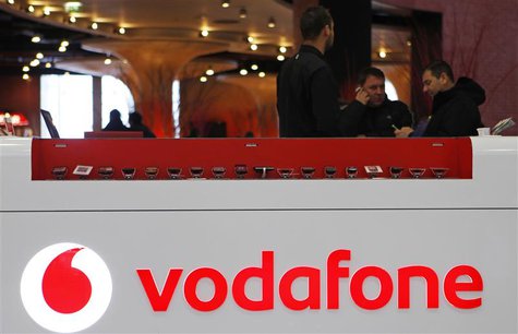 The Vodafone logo is seen at the counter of the shop as customers look at mobile phones in Prague February 7, 2012. British telecommunicatio The Vodafone logo is seen at the counter of the shop as customers look at mobile phones in Prague February 7, 2012. British telecommunicatio
