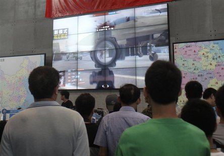 Visitors look at a screen, displaying the video game "Glorious Mission Online", under a Chinese national flag during the China Digital Enter Visitors look at a screen, displaying the video game "Glorious Mission Online", under a Chinese national flag during the China Digital Enter