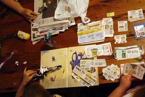 Katie Busker, 30, clips coupons as her son, Austin Spiker, 6, plays with Legos at the dinner table in Independence, Iowa July 5, 2011. REUTE Katie Busker, 30, clips coupons as her son, Austin Spiker, 6, plays with Legos at the dinner table in Independence, Iowa July 5, 2011. REUTE
