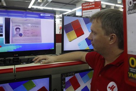 A shop assistant looks at a screen broadcasting an image of the document which grants Edward Snowden temporary asylum status for a year, in A shop assistant looks at a screen broadcasting an image of the document which grants Edward Snowden temporary asylum status for a year, in