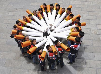 Students pose for pictures with "big cigarette models" during a campaign ahead of the World No Tobacco Day, at a primary school in Handan, H Students pose for pictures with "big cigarette models" during a campaign ahead of the World No Tobacco Day, at a primary school in Handan, H