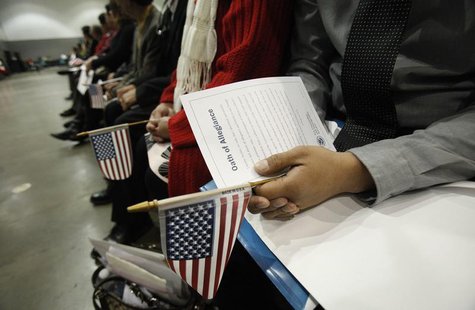 Candidates hold U.S. flags during a naturalization ceremony to become new U.S. Citizens at Convention Center in Los Angeles, California Febr Candidates hold U.S. flags during a naturalization ceremony to become new U.S. Citizens at Convention Center in Los Angeles, California Febr