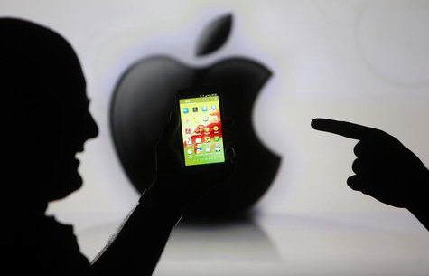 Men are silhouetted against a video screen with an Apple Inc logo as they pose with a Samsung Galaxy S3 smartphone in this photo illustratio Men are silhouetted against a video screen with an Apple Inc logo as they pose with a Samsung Galaxy S3 smartphone in this photo illustratio