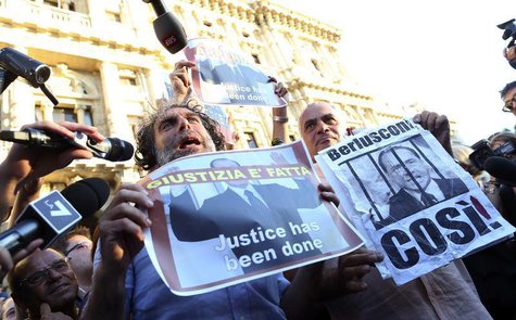Two men hold up posters depicting former Italian Prime Minister Silvio Berlusconi during a protest in front of Italy's supreme court buildin Two men hold up posters depicting former Italian Prime Minister Silvio Berlusconi during a protest in front of Italy's supreme court buildin