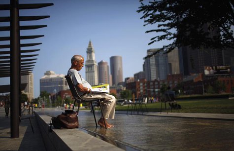 A man soaks his feet in a fountain while reading a magazine on the Rose Kennedy Greenway on a warm summer afternoon in Boston, Massachusetts A man soaks his feet in a fountain while reading a magazine on the Rose Kennedy Greenway on a warm summer afternoon in Boston, Massachusetts