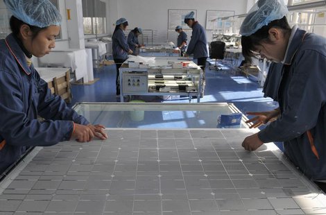 Employees work at the solar cells production line of the Blue Carbon Technology Inc. in Rizhao, Shandong province December 3, 2010. REUTERS/ Employees work at the solar cells production line of the Blue Carbon Technology Inc. in Rizhao, Shandong province December 3, 2010. REUTERS/