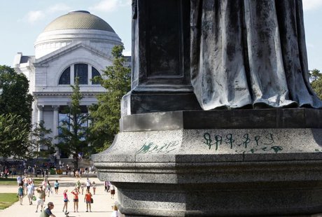 A close up shows markings in green paint on the base of a statue of Joseph Henry, the first secretary of the Smithsonian Institution, outsid A close up shows markings in green paint on the base of a statue of Joseph Henry, the first secretary of the Smithsonian Institution, outsid