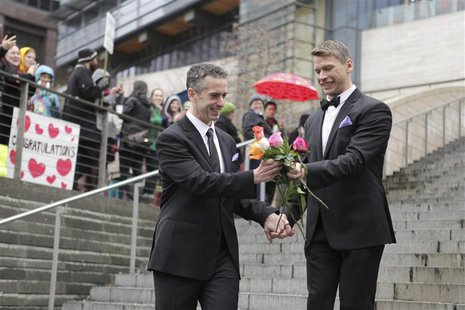 Seattle gay-rights advocate and journalist Dan Savage (L) and Terry Miller sort through roses on the steps of City Hall after getting marrie Seattle gay-rights advocate and journalist Dan Savage (L) and Terry Miller sort through roses on the steps of City Hall after getting marrie
